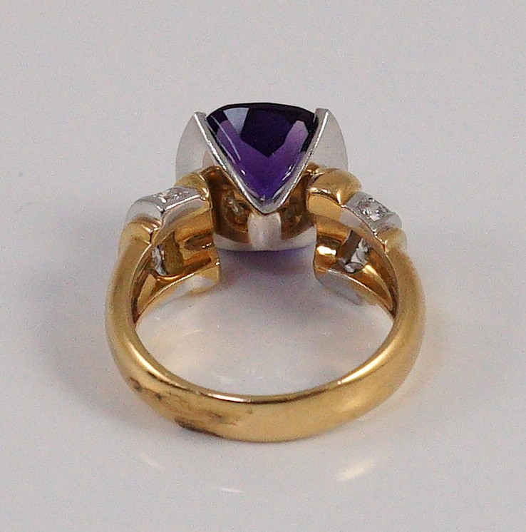 A modern 18ct gold and single stone cushion cut amethyst set dress ring, with ten stone diamond set shoulders